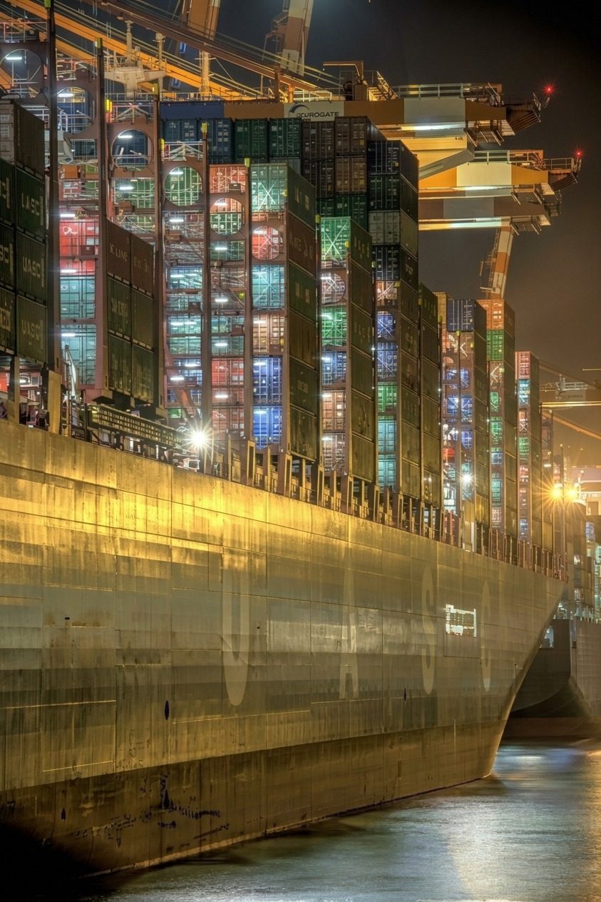 Buque portacontenedores cargado, iluminado de noche en una terminal portuaria